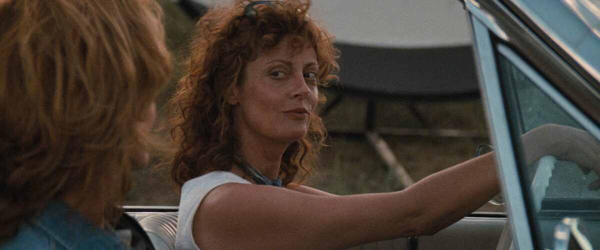 Susan Sarandon, au volant de la décapotable regarde sa camarade Geena Davis.